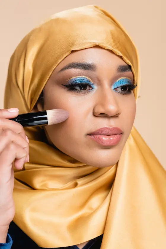 young-muslim-woman-in-yellow-hijab-applying-makeup-2024-11-15-09-53-16-utc